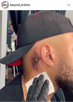 a man with a tattoo on his neck and behind his ear is looking in the mirror