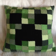 a green and black pillow sitting on top of a bed