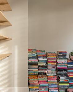 a stack of books sitting on top of a wooden shelf