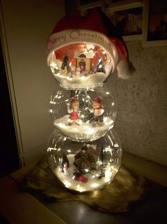 three snow globes are stacked on top of each other with christmas decorations in them