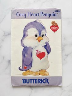 the front cover of a children's book with an image of a penguin holding a heart