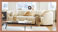 a living room with a white couch and coffee table in front of a large window