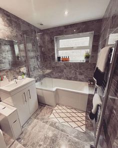 a bathroom with marble floors and walls, including a bathtub that is next to a sink