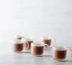 six coffee mugs lined up on a table