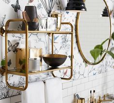 a bathroom with gold fixtures and floral wallpaper on the walls, along with black and white accessories