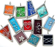 a bunch of different colored glass pendants on a white surface with one being an omen symbol