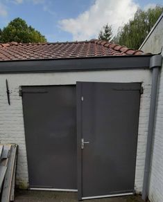 two garage doors are open in front of a white brick building