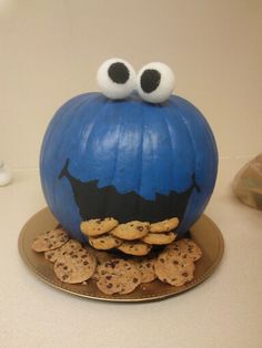 a blue pumpkin with googly eyes sitting on top of crackers