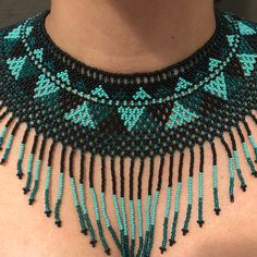 a woman wearing a blue and black beaded necklace with beads on the neckline