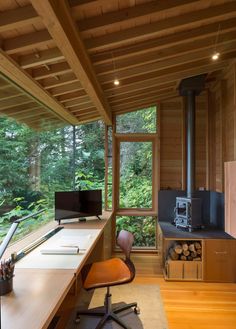 a room with a desk, chair and television inside of it on the wooden floor