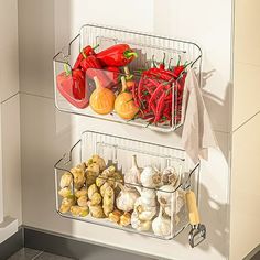 two metal baskets filled with vegetables on top of a kitchen counter next to a sink