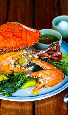 a blue plate topped with lobsters and vegetables