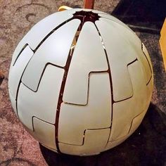 a large white ball sitting on top of a floor next to a wooden pole and sidewalk