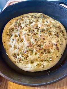 an uncooked pizza sitting in a pan on top of a wooden table