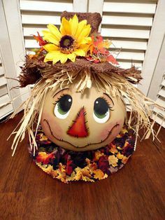 a pumpkin with a scarecrow's hat and sunflowers on it