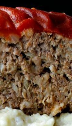 meatloaf with mashed potatoes and ketchup on a black background, close up