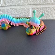 Love many-legged critters? Check out this adorable, colorful millipede pet! This long arthropod is the perfect unique desk buddy. Articulated joints allow this little critter to wiggle many legs and flex along many body joints for a fun fidget experience. Size: ~11 inches long (varies as it flexes!)  Because these millipedes are printed in variegated material, arrangement of colors may differ from print to print. These colors will be present, but there may be a different beginning/ending color, Desk Pet, Bug Gifts, Cute Desk Decor, Desk Buddy, Body Joints, Unique Desks, 3d Figures, Cute Desk, Math Art