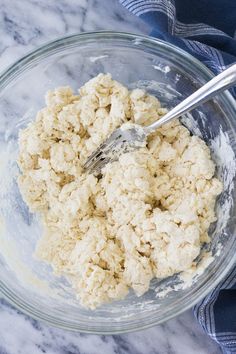 a glass bowl filled with oatmeal next to a blue and white towel