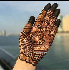 the hand is decorated with henna designs on it's fingers and palm hands