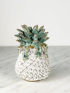 a ceramic pineapple on a marble table