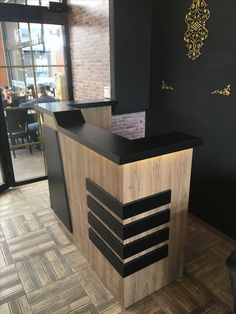 a black and wood reception counter in a restaurant or bar with people sitting at the tables