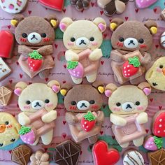 there are many decorated teddy bears on the table with hearts and other treats in front of them