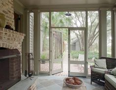 a living room filled with furniture and a fire place in front of a glass door