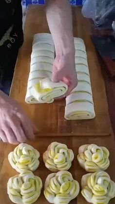 someone is decorating cupcakes with icing on a cutting board