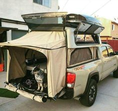 the truck is parked on the side of the road with its roof tent opened up