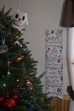 a decorated christmas tree in front of a wall hanging