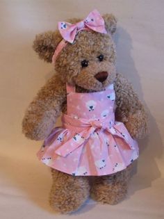 a brown teddy bear wearing a pink dress