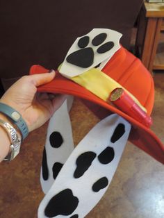 a hand holding a hat with paw prints on it