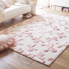 a white couch and pink rug in a room