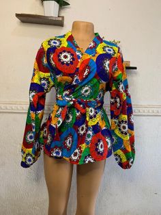 Ankara peplum wrap top is perfect for all occasions including weddings, anniversaries, baby dedication, religious services, bridal showers and parties. It can be worn with skirt, shorts or trouser depending on your choice. This unique piece has a detachable self tie belt and is made with high quality Ankara fabric sourced from Nigeria. Items are shipped from Canada If you have any inquiries, please feel free to start an etsy conversation. CARE INSTRUCTIONS * Hand wash with warm water. * Do not b Fitted Multicolor Tops For Wedding, Multicolor Tops For Spring Wedding, Fitted Floral Print Wrap Top, Multicolor Spring Wedding Tops, Spring Wedding Multicolor Tops, Fitted Tie Waist Blouse For Party, Fitted Blouse With Kimono Sleeves For Spring, Multicolor Wrap Blouse, African Print Blouse