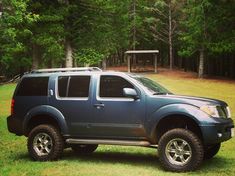 a blue pick up truck parked in the grass