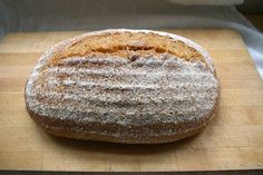 a loaf of bread sitting on top of a wooden cutting board