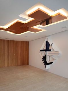 an empty room with wooden paneling and white walls is lit by recessed lights