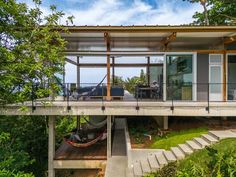 the house is surrounded by trees and has stairs leading up to it's roof