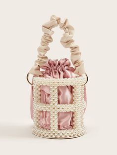 a pink and white bag with pearls on the handle, tied in a knot around it