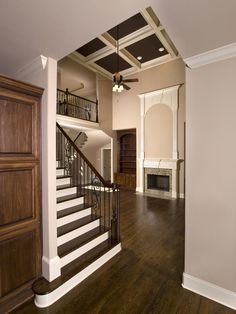 an empty living room with wood floors and stairs