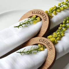 two napkins with flowers on them are sitting on a white plate, next to each other