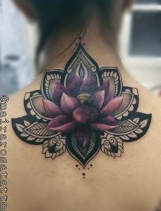 the back of a woman's neck with a lotus tattoo on it