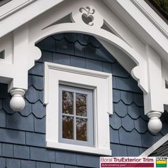 the corner of a blue house with white trim and windows on it's sides