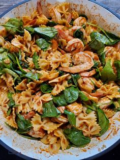 pasta with shrimp and spinach in a white bowl