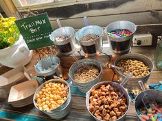 several buckets filled with different types of food on a table next to a sign