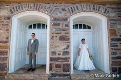 a bride and groom standing in front of two doors