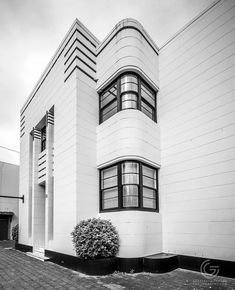 a black and white photo of a building with two windows on the side of it