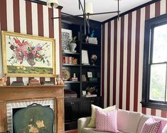 a living room filled with furniture and a fire place in front of a striped wall