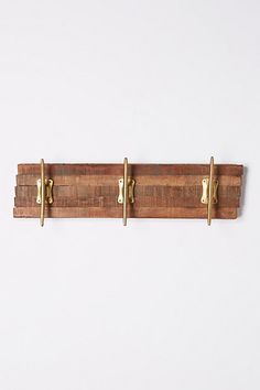 a wooden coat rack with three brass handles