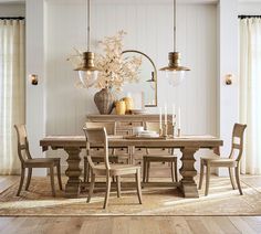 a dining room table with chairs and a vase filled with flowers on top of it